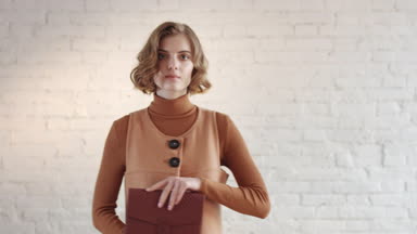 Fashion girl posing on camera with leather handbag