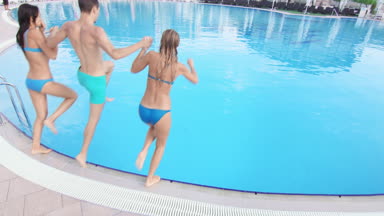 Three friends run and jump in pool