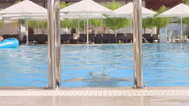 Young woman exit the pool by ladder