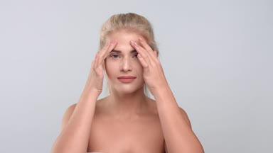 Beauty portrait of young blonde woman touch her skin.