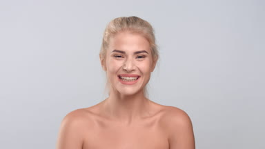 Young blonde woman looking at the camera and laughing
