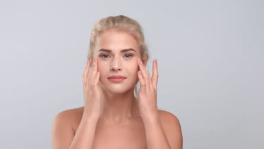 Young woman touching her elastic and firm face skin