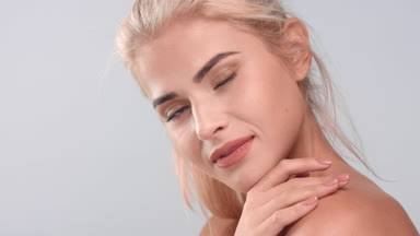 Young woman tenderly touching her soft skin | Skincare concept