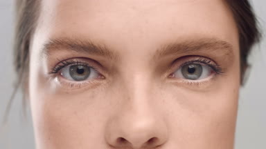 Young Caucasian woman opening her eyes in front of camera