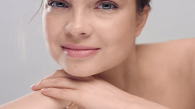Woman raises her head from her arm and touch her skin