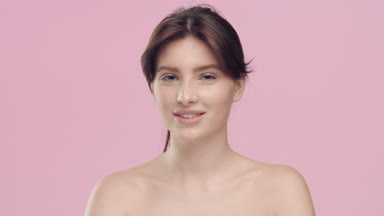 Yung pretty woman with healthy skin looks at camera and smile
