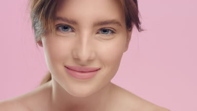 Young woman with smooth healthy skin looks at camera and smile.