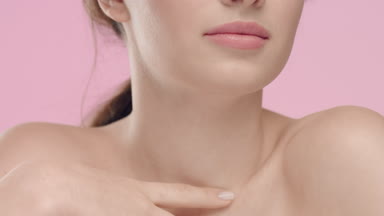 Young woman touching her smooth skin in collarbone area