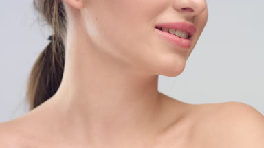 Young woman with smooth healthy skin smiles widely