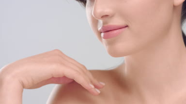 Woman with healthy smooth skin turning face to camera and smiles