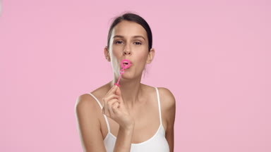 Young slim woman blowing soap bubbles and smiling. Slow motion