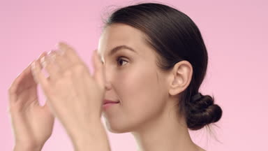 Young woman softly touch her face skin and turns to the camera