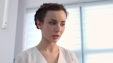 Female dermatologist exams patient's skin using dermatoscope