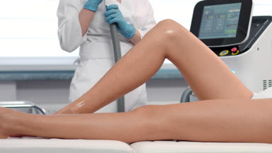 Slow motion shot of Laser hair removal procedure on female legs.