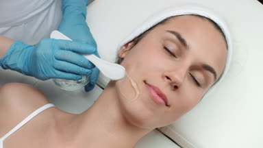 Cosmetologist applying ipl gel on patient's face