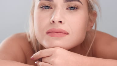 Woman puts her chin on her hand and looks at the camera