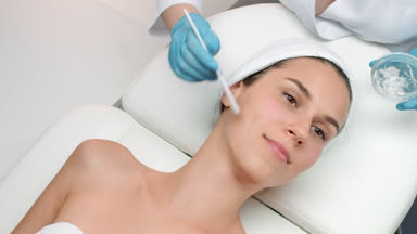 Cosmetologist applying ipl gel on patient's face