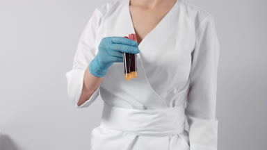 Doctor demonstrates two tubes with blood samples