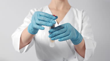 Nurse puts blood sample tube with specimen in centrifuge tube