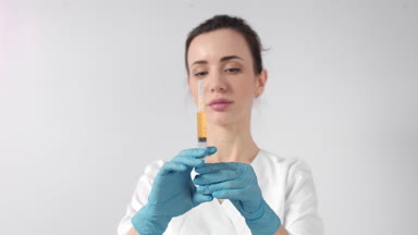 Cosmetologist preparing syringe with blood plasma
