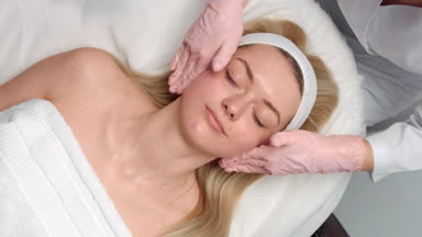 Time lapse of cosmetology facial massage procedure pink gloves