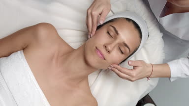 Top view of Cosmetology facial massage procedure young woman