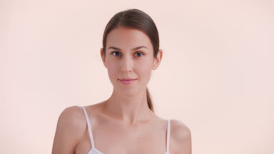 Brunette beauty model turns to and looks at camera and smiles