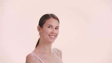 Brunette woman looks at camera, smiles, turns back and goes away
