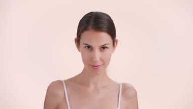 Beauty model lifts her chin, looks up at camera and smiles
