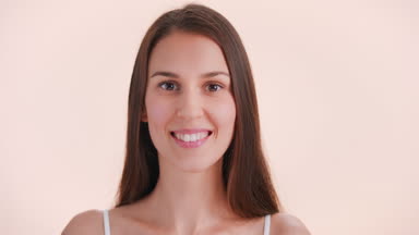 Brown-haired woman turns to the camera look at camera and smiles