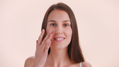 Brunette beauty model turns and look at camera touching her face