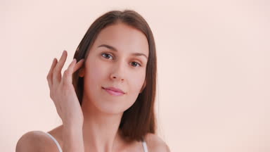 Young woman touches her face sliding fingers along the jawline