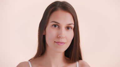 Young woman makes a beauty cream smear on her face