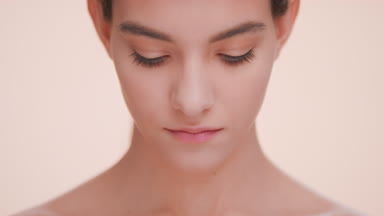 Young woman raise her face and look up into the camera.