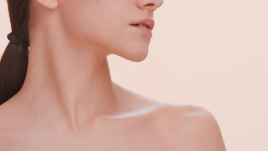 Beauty model softly strokes her clavicles.