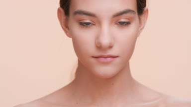 Beauty woman gently strokes her face skin and looks at camera