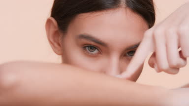 Beauty woman strokes hand with a finger and looks at the camera