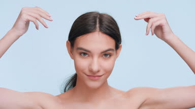 Young woman demonstrates skin pureness, elasticity and freshness