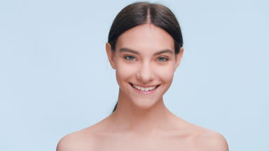 Positive beauty model turns and looks at the camera and smiles