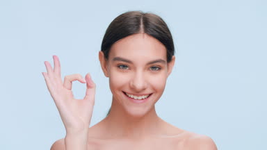 Young woman made an ok hand gesture and smile