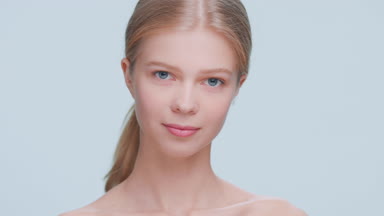 Young attractive blonde beauty model slowly turns to the camera