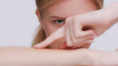 Beauty model touches her forearm skin and looks at the camera