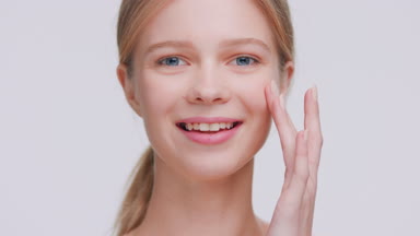 Girl touches her elastic skin near the cheek with her fingers
