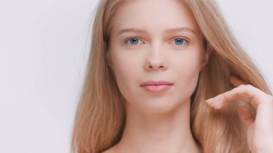 Blonde beauty model touches her perfect skin