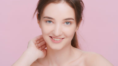 Beauty woman looks at the camera and gently touches her face