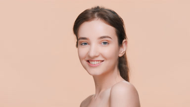 Brunette woman posing for a skin care product commercial