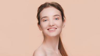 Brunette woman with a ponytail turns to the camera and smiles