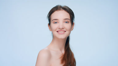 Beauty woman with a ponytail turns to the camera and smiles