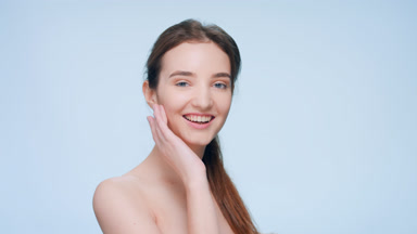 Young woman turns to the camera and touch her cheek twice