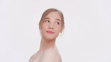 Young woman turns her body looks at camera and smiles